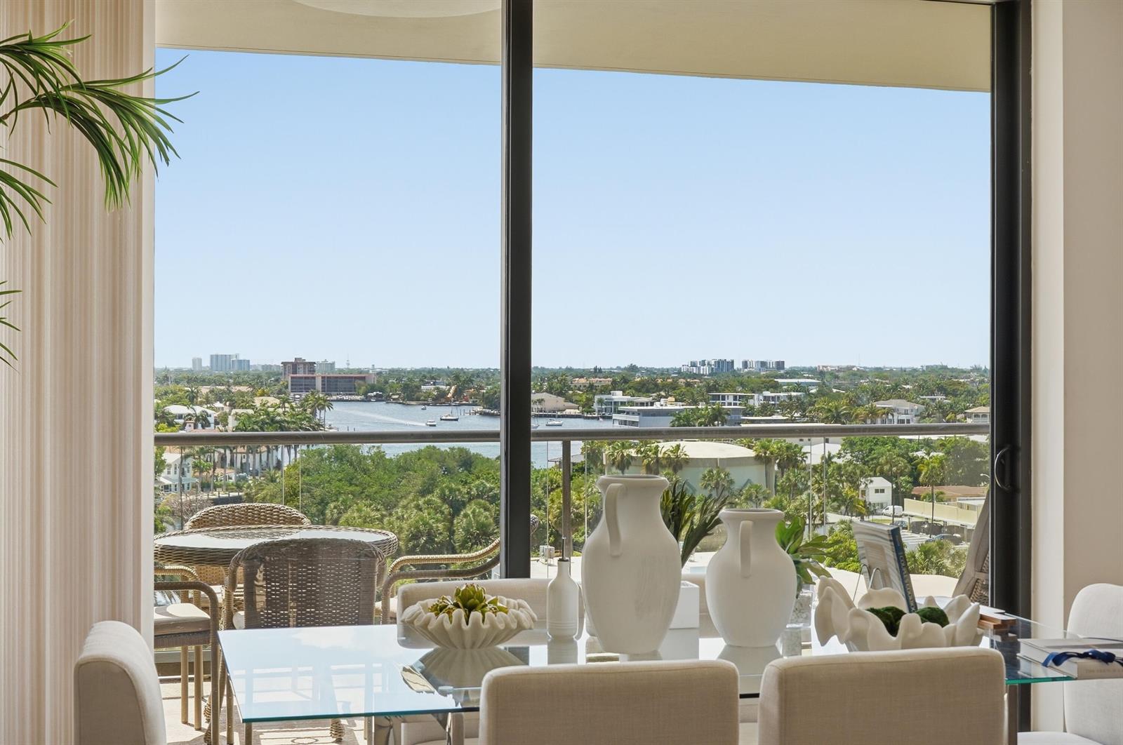 A dining area with a glass table overlooks a balcony and a waterfront city view — 1300 S Ocean Boulevard # 705, Pompano Beach FL 33062, POMPANO BEACH, FL