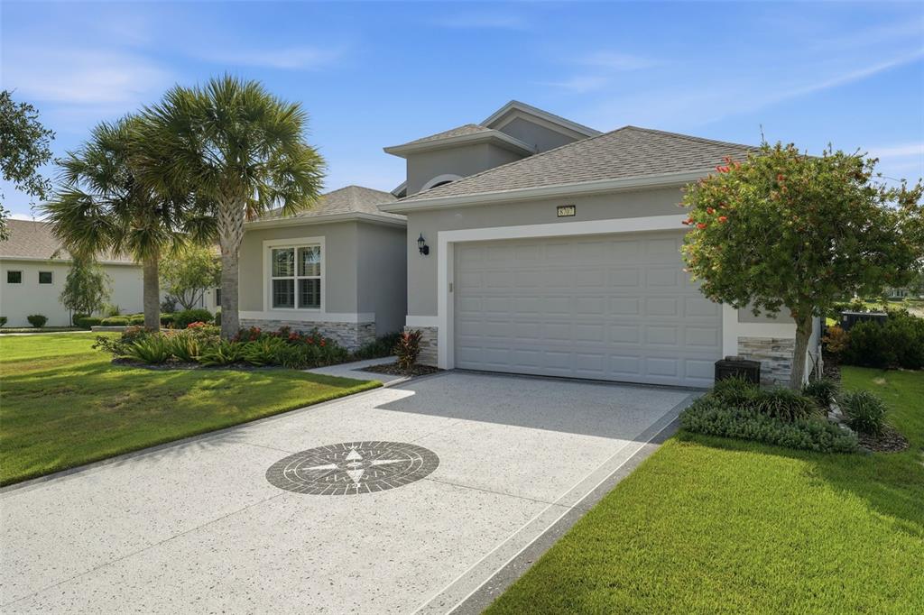 A single-story house with a gray exterior, a two-car garage, and palm trees in front — 8707 PROVIDENCE CT, MOUNT DORA, FL