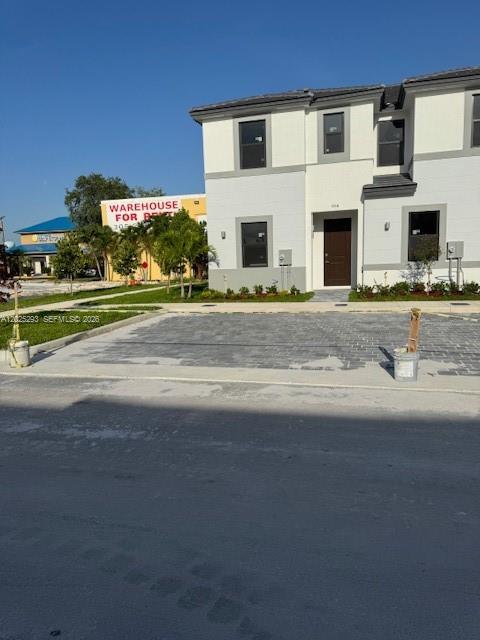 A two-story residential building with a paved parking area in front — FLORIDA CITY, FL