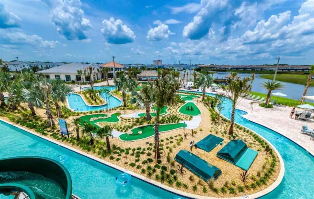An aerial view of a resort pool area featuring a lazy river and putting green — 3150 PARADOX CIRCLE UNIT 305, KISSIMMEE, FL