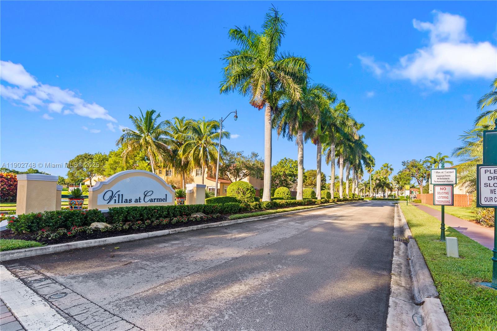The entrance to the Villas at Carmel features a sign, palm trees, and a road — 1398 NE 33rd Ave # 25, Homestead FL 33033, HOMESTEAD, FL
