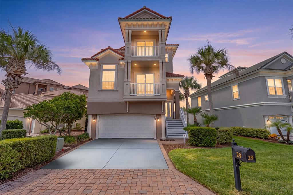 A three-story house with a two-car garage, two stacked balconies, and a paved driveway — 29 NORTHSHORE AVENUE, PALM COAST, FL
