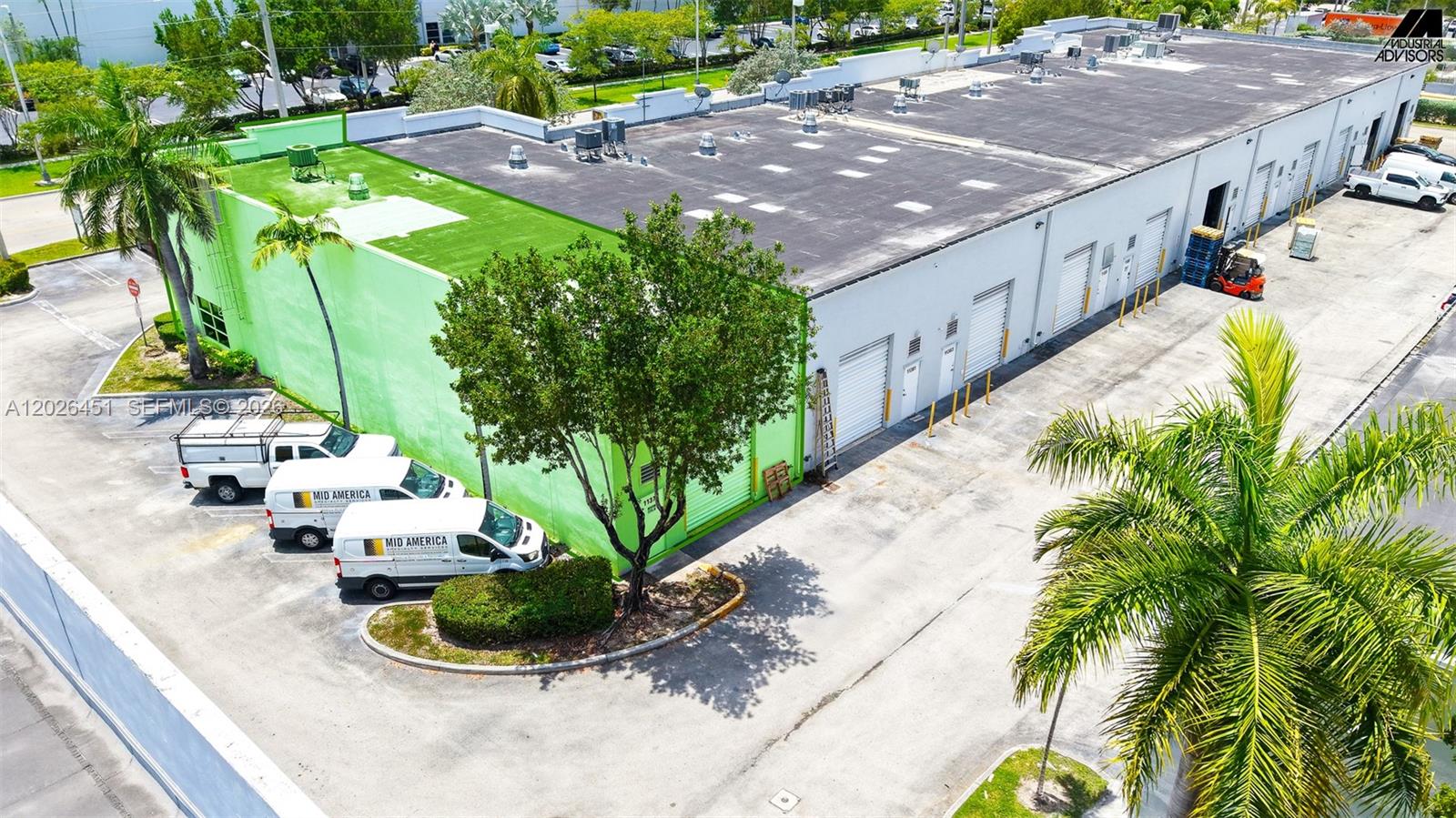 An aerial view shows a commercial warehouse building with a bright green exterior wall — 11379 NW 122nd St # 11, Medley FL 33178, MEDLEY, FL