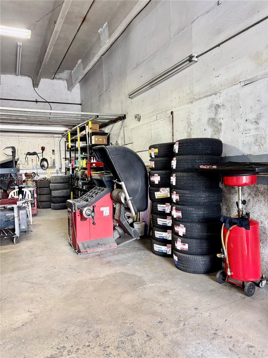 An auto repair shop features tire stacks, a tire balancing machine, and an oil drain — 11750 NW 87th Pl, Hialeah Gardens FL 33018, HIALEAH GARDENS, FL