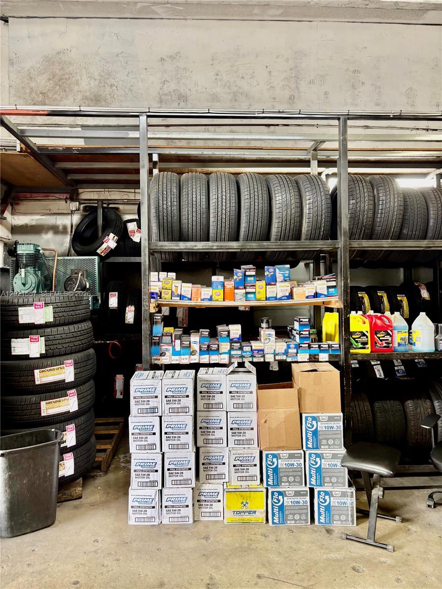 A storage room contains stacks of tires, shelves of motor oil, and automotive supplies — 11750 NW 87th Pl, Hialeah Gardens FL 33018, HIALEAH GARDENS, FL