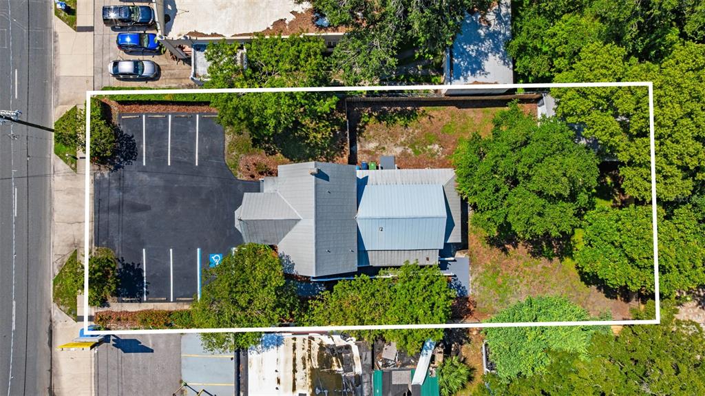 An aerial view shows a building with a metal roof, a parking lot, and trees — 4206 NEBRASKA AVENUE N, TAMPA, FL