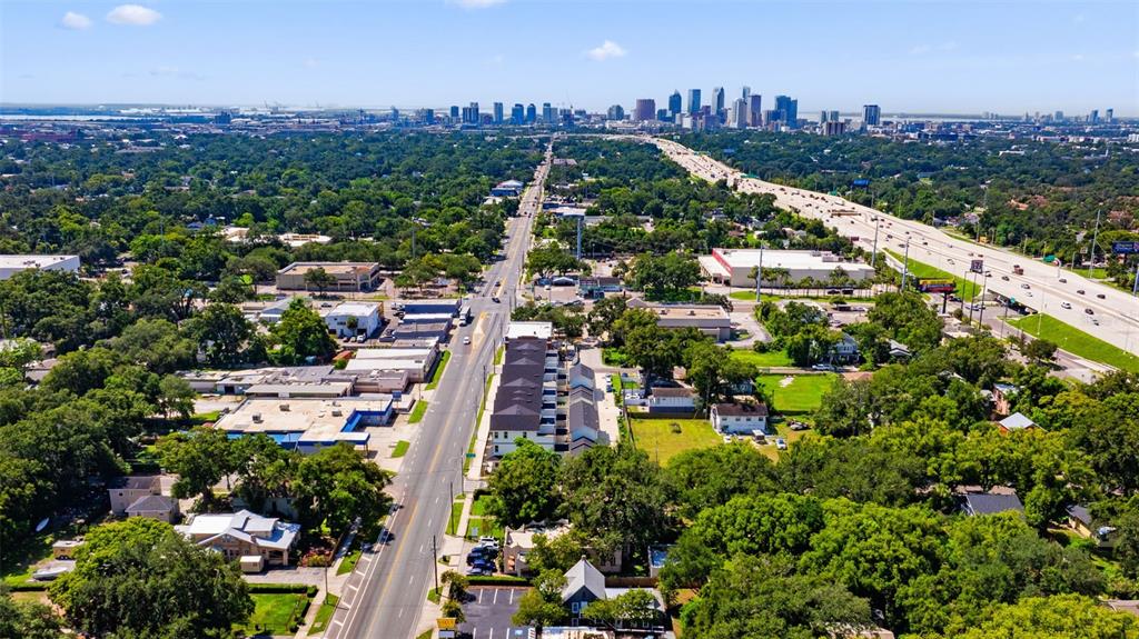 An aerial view shows a residential street leading toward a distant city skyline and highway — 4206 NEBRASKA AVENUE N, TAMPA, FL