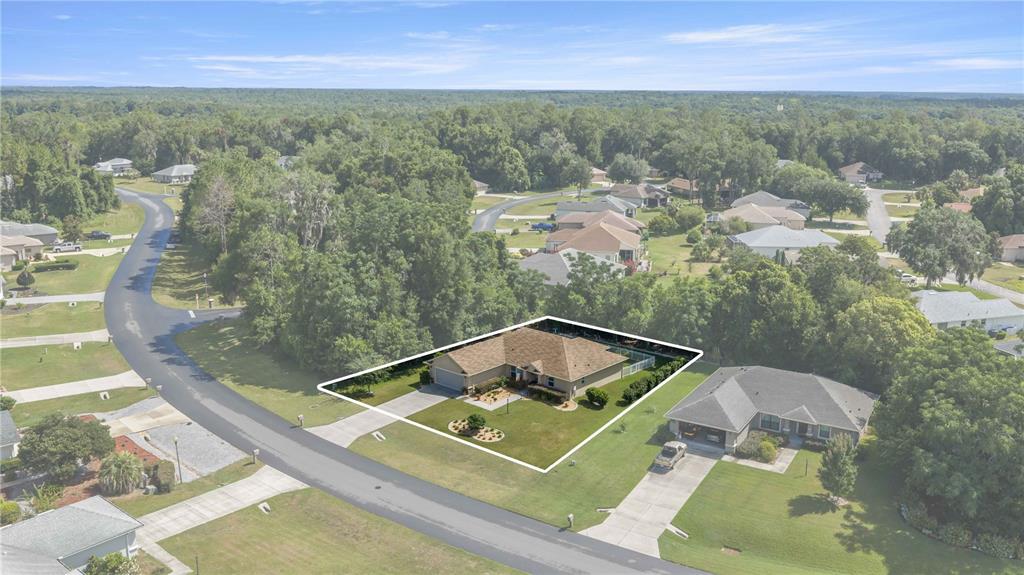 An aerial view shows a single-story suburban house with a tan roof and lawn — 3125 N CANTERBURY LAKE DRIVE, HERNANDO, FL