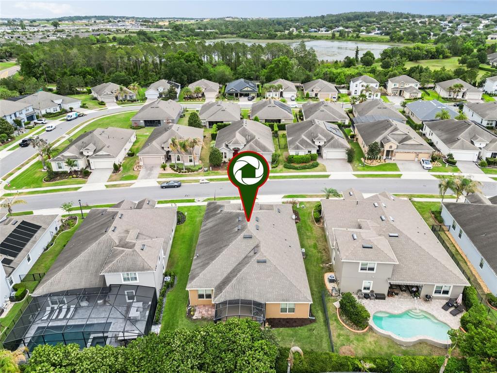 An aerial view shows a suburban neighborhood with a focus on a single-story residential house — 588 AUTUMN ASH DRIVE, CLERMONT, FL