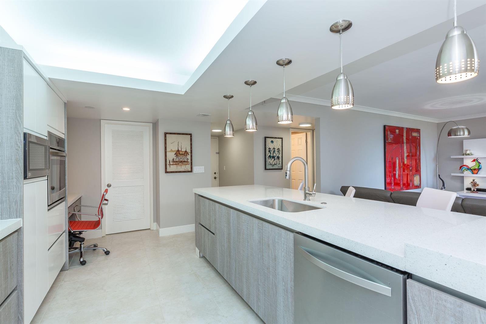 A modern kitchen features a white quartz island, stainless steel appliances, and light wood cabinetry — 2455 Lindell Boulevard # 3304, Delray Beach FL 33444, DELRAY BEACH, FL