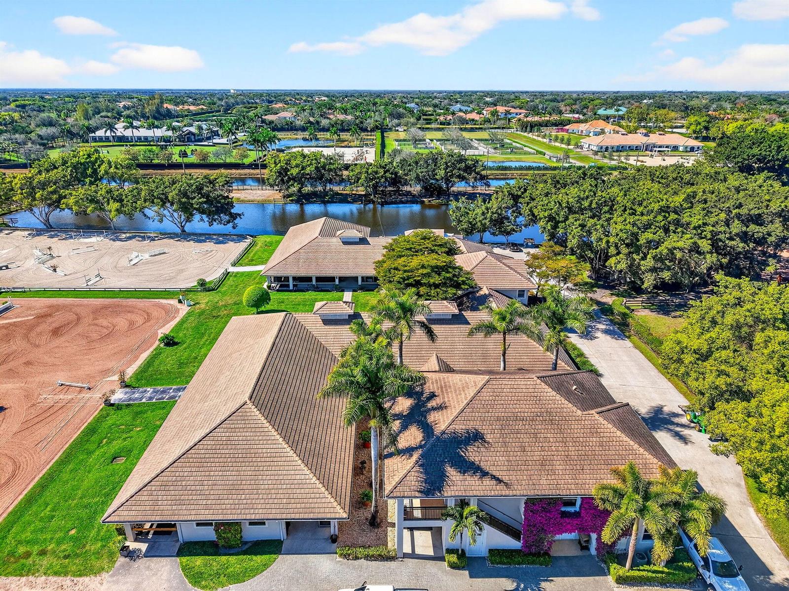 An aerial view shows a large equestrian estate with stables, riding arenas, and a pond — 3405 Olde Hampton Drive, Wellington FL 33414, WELLINGTON, FL
