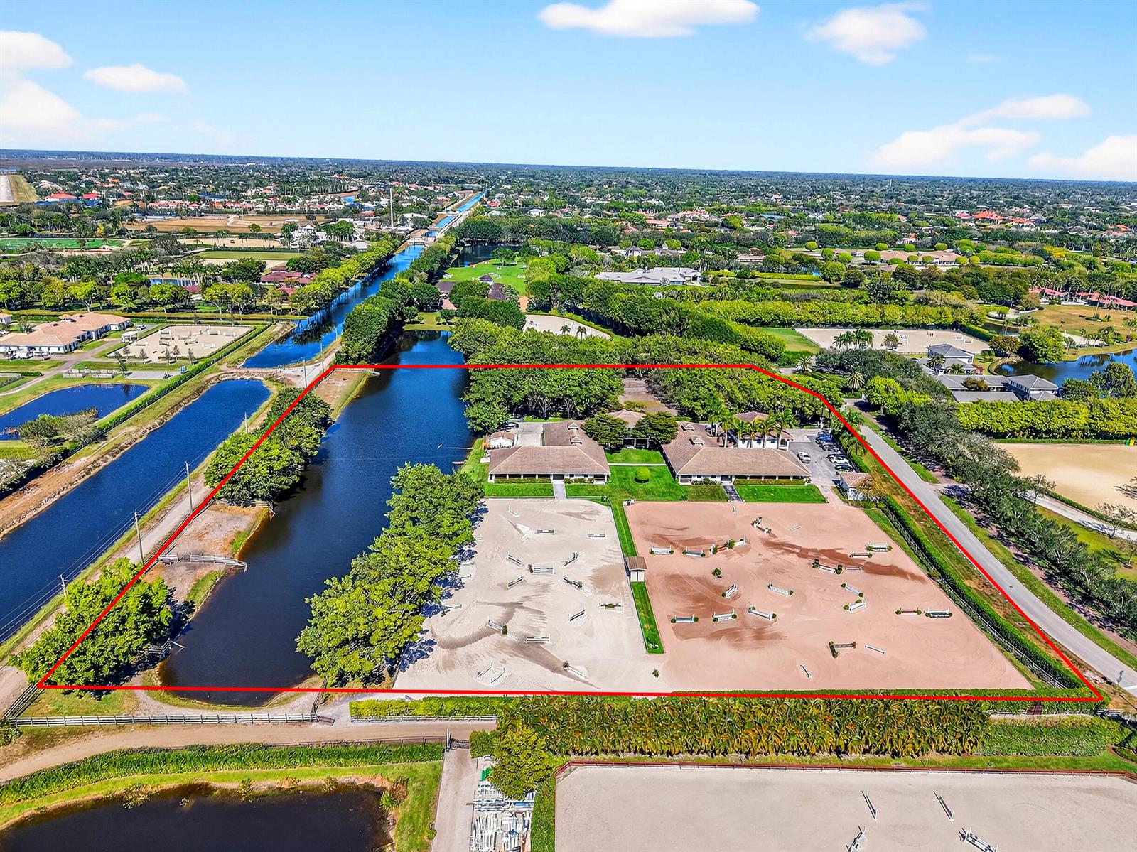 An aerial view shows an equestrian property with two barns and two large riding arenas — 3405 Olde Hampton Drive, Wellington FL 33414, WELLINGTON, FL