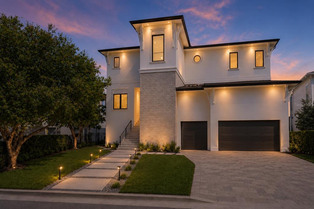 A modern two-story house with a stone facade, a paved driveway, and a landscaped walkway — 654 GENEVA PLACE, TAMPA, FL