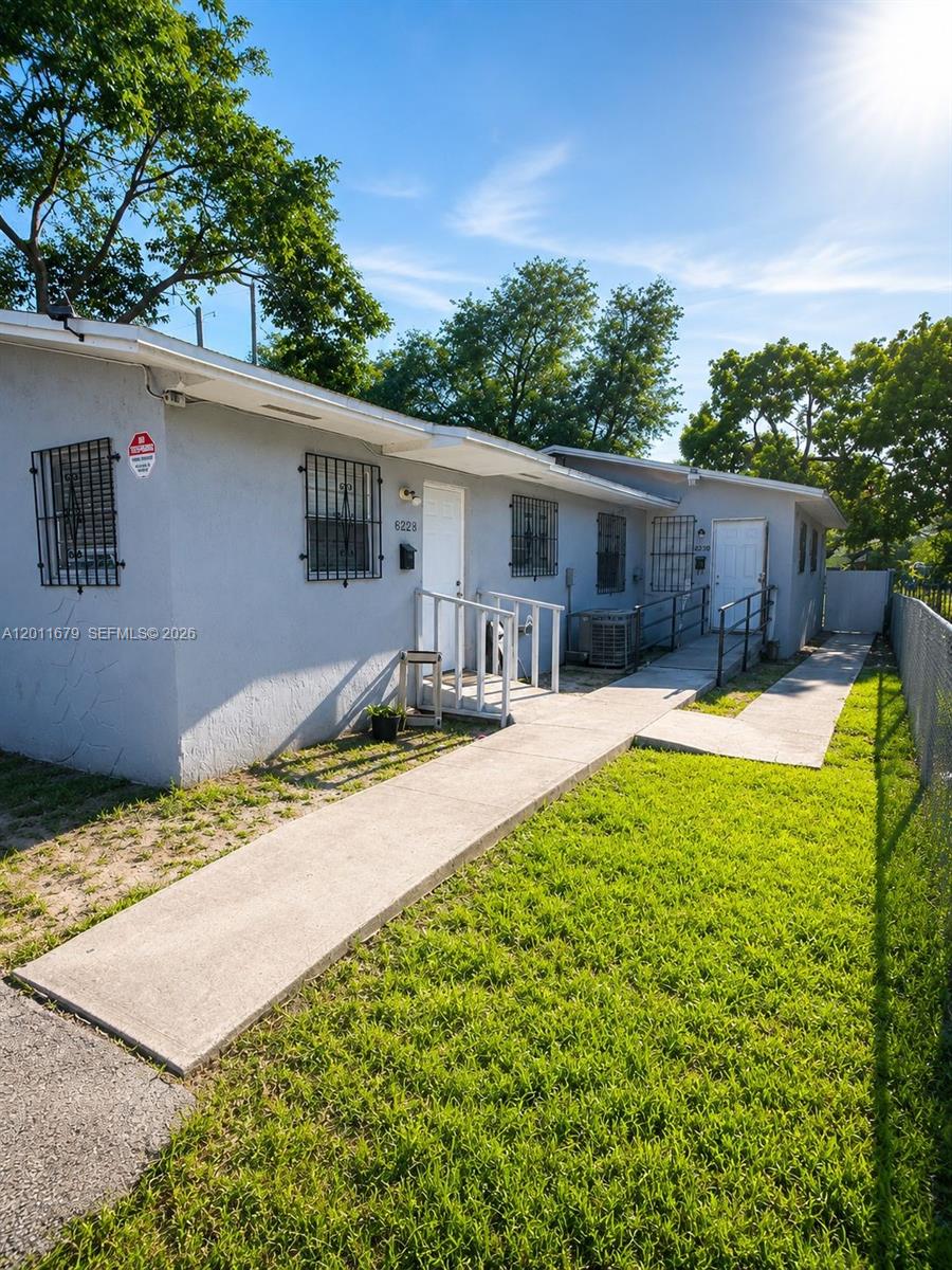 A single-story gray building with a concrete walkway and metal security bars on the windows — 6228 NW 4th Ave, Miami FL 33150, MIAMI, FL
