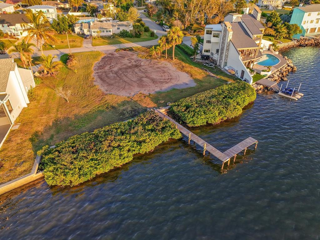 An aerial view shows a vacant waterfront lot with a wooden dock and mangrove vegetation — 2308 PALMA SOLA BOULEVARD, BRADENTON, FL