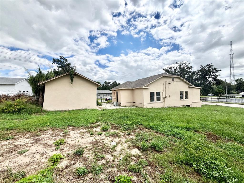 A view of the rear exterior of a house and a detached garage — 1020 E MAIN STREET, HAINES CITY, FL