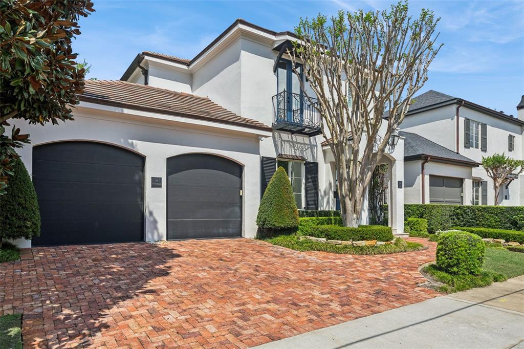 A two-story house with a brick driveway, two garage doors, and a small balcony — 621 HUNTINGTON AVENUE, WINTER PARK, FL