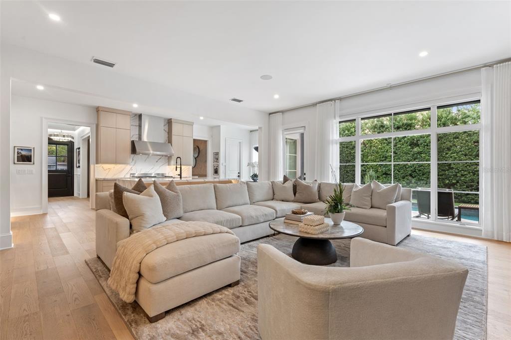 A spacious living room features a large sectional sofa, a coffee table, and an open kitchen — 621 HUNTINGTON AVENUE, WINTER PARK, FL