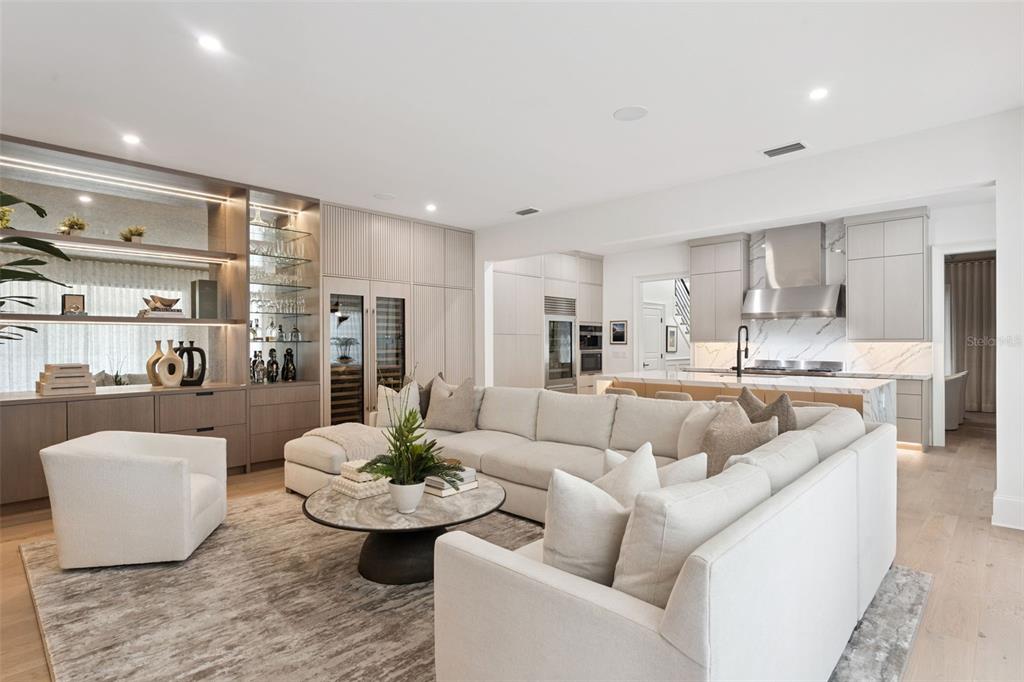 A modern open-concept living room features a large sectional sofa, marble coffee table, and kitchen — 621 HUNTINGTON AVENUE, WINTER PARK, FL