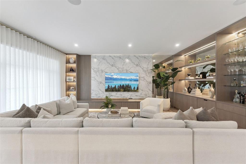A living room features a marble accent wall with a television, sectional sofa, and shelving — 621 HUNTINGTON AVENUE, WINTER PARK, FL
