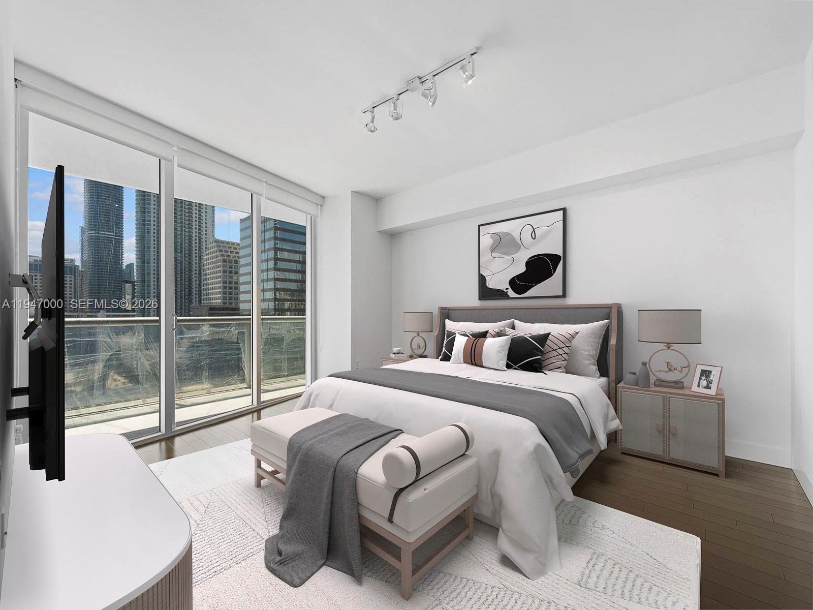 A modern bedroom features a bed, a bench, and floor-to-ceiling windows overlooking city skyscrapers — 495 Brickell Ave # 1801, Miami FL 33131, MIAMI, FL