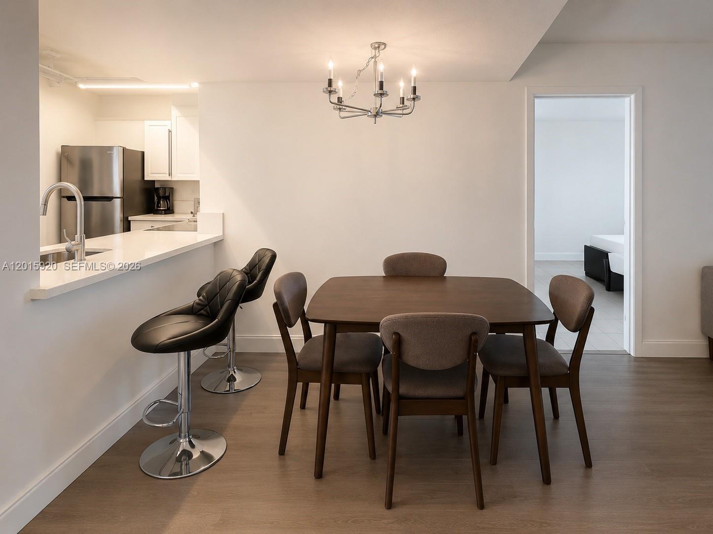 A dining area with a wooden table and chairs sits next to a kitchen counter — 14170 SW 84th St # F, Miami FL 33183, MIAMI, FL