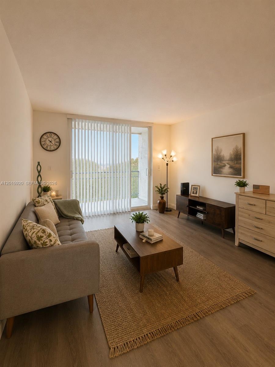 A living room features a gray sofa, wood coffee table, media console, and a balcony door — 14170 SW 84th St # F, Miami FL 33183, MIAMI, FL