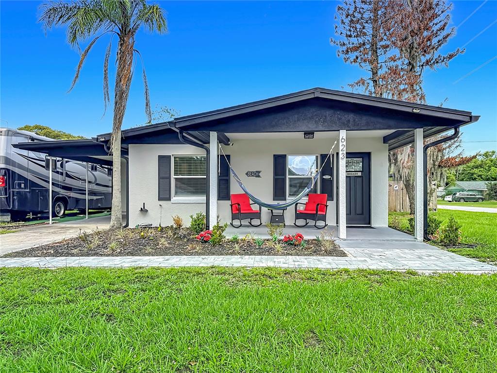 A single-story house with a covered front porch, a hammock, and an adjacent carport — 623 JERSEY AVENUE, ST CLOUD, FL