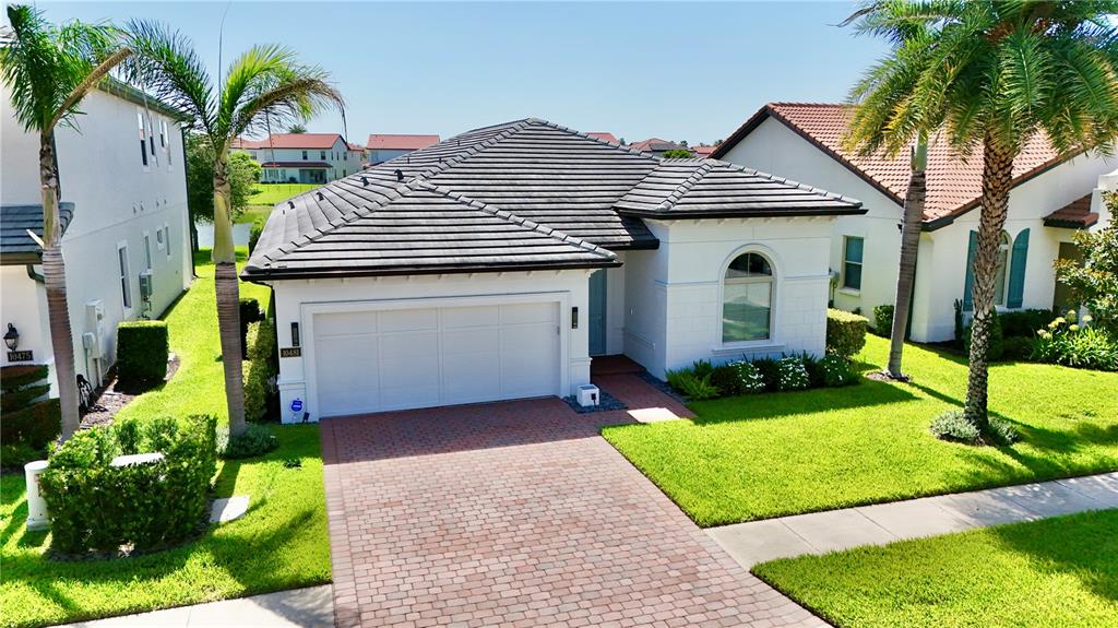 A laundry room features a utility sink, granite countertop, white cabinets, and two gray appliances — 10481 ROYAL CYPRESS WAY, ORLANDO, FL