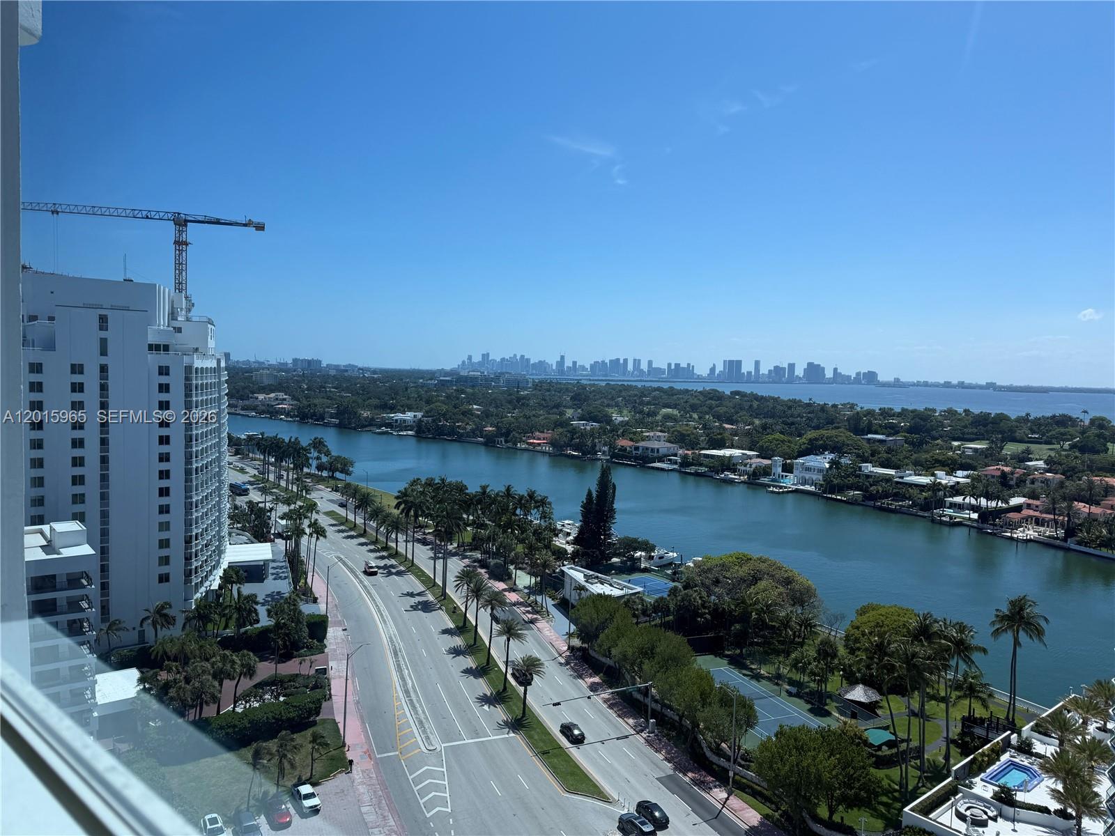 An elevated view shows a coastal road, a waterway, and a distant city skyline — 5445 Collins Ave # 1606, Miami Beach FL 33140, MIAMI BEACH, FL