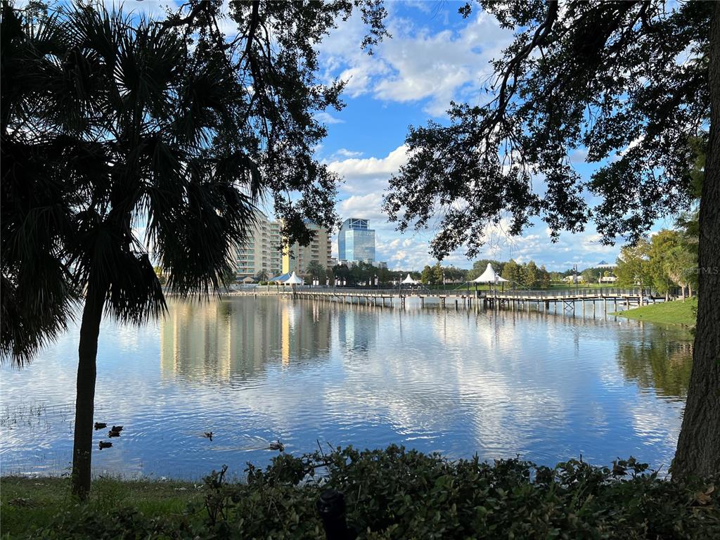 A view of a lake with a wooden pier, surrounding buildings, and trees under a sky — 133 OYSTER BAY CIRCLE UNIT 100, ALTAMONTE SPRINGS, FL