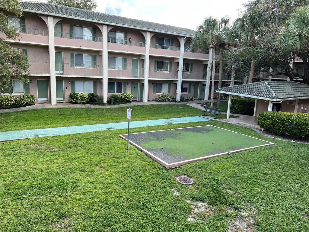 An exterior view shows a three-story apartment building with a lawn and a shuffleboard court — 133 OYSTER BAY CIRCLE UNIT 100, ALTAMONTE SPRINGS, FL