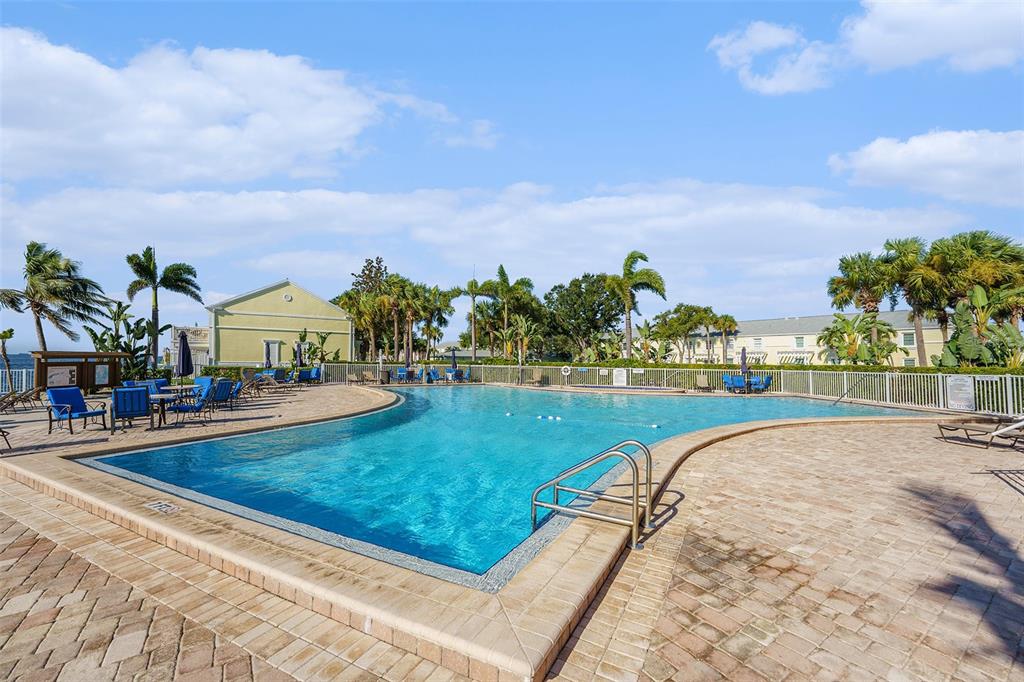 A living room features tile flooring, a gray loveseat, and sliding doors overlooking a marina — 5176 SALMON DRIVE SE UNIT A, ST PETERSBURG, FL