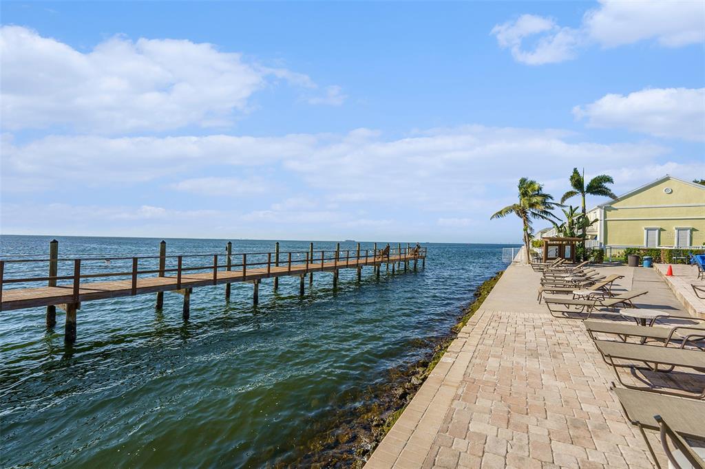 A brick patio overlooks a canal with docked boats and multi-story residential buildings — 5176 SALMON DRIVE SE UNIT A, ST PETERSBURG, FL