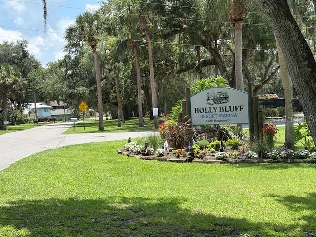 A sign for Holly Bluff Resort Marina stands in a grassy area with many trees — 2263 HONTOON ROAD, DELAND, FL