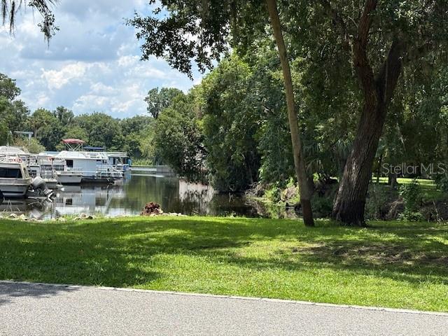 A view of a grassy lawn leading to a canal with several docked boats — 2263 HONTOON ROAD, DELAND, FL