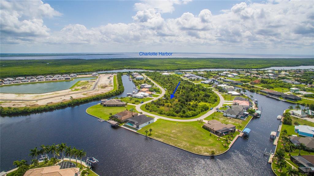 An aerial view shows a vacant, wooded residential lot situated along a canal in Florida — 15505 MARGO CIRCLE, PORT CHARLOTTE, FL