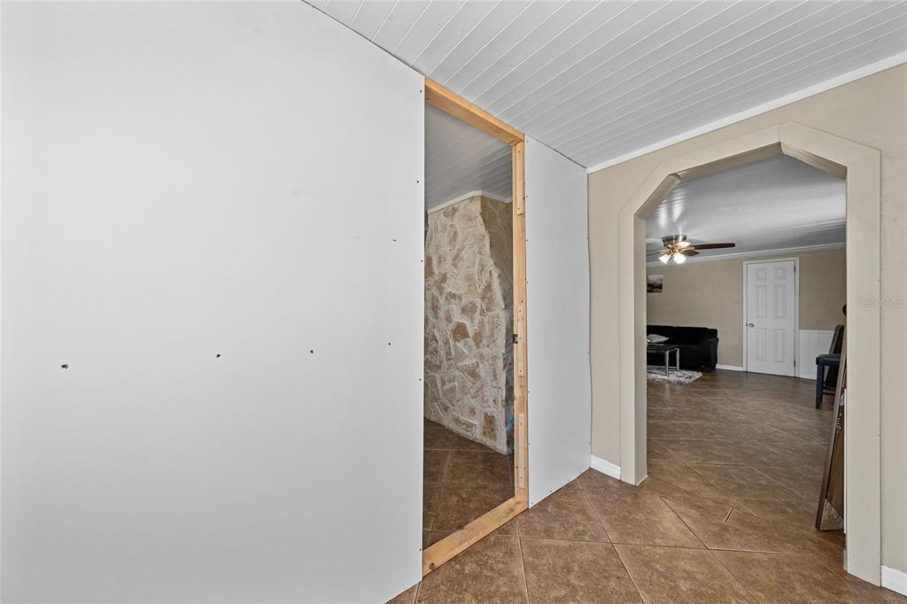 A room under renovation features unfinished drywall panels installed around a wooden door frame — 518 TOHOPEKALIGA AVENUE, KISSIMMEE, FL