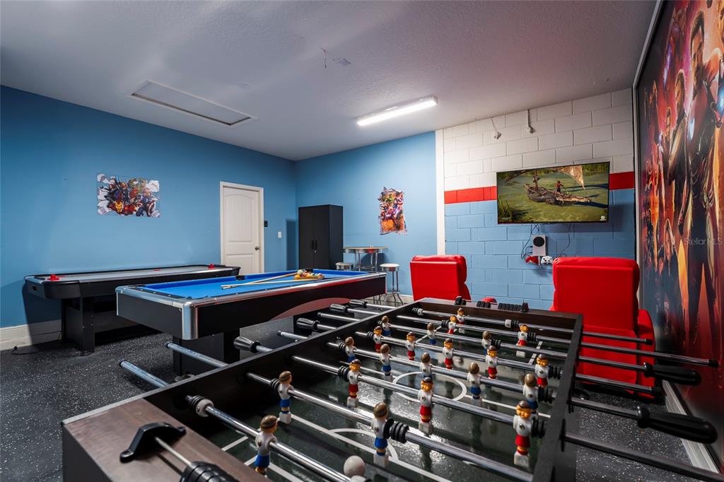 A game room features a foosball table, pool table, air hockey table, and wall-mounted television — 5145 OAKBOURNE AVENUE, DAVENPORT, FL