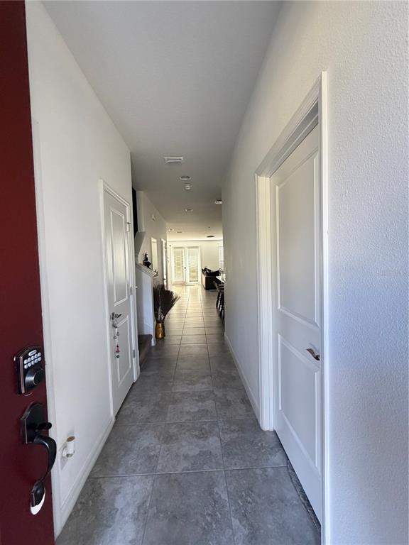 A tiled hallway leads from an entryway toward a living area with white walls — 11102 HANLON TERRACE ALLEY, WINTER GARDEN, FL