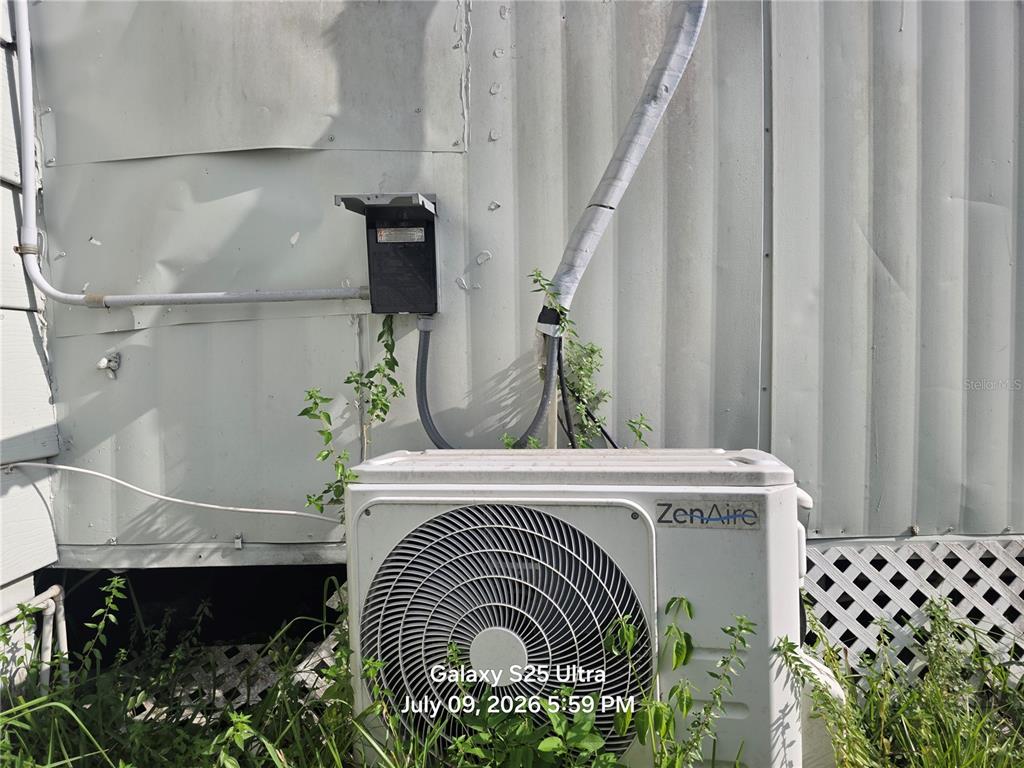 An outdoor ZenAire HVAC unit is mounted against the exterior wall of a building — 2926 VOUSDEN LANE, LAKELAND, FL