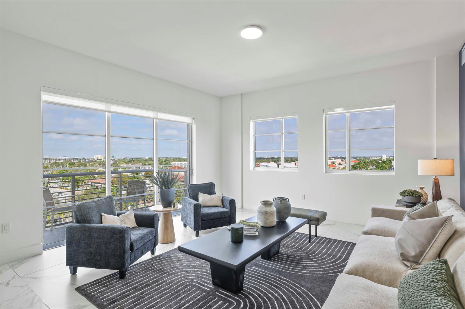 A living room features a large rug, a coffee table, armchairs, and a balcony view — 155 E Boca Raton Road # 823, Boca Raton FL 33432, BOCA RATON, FL