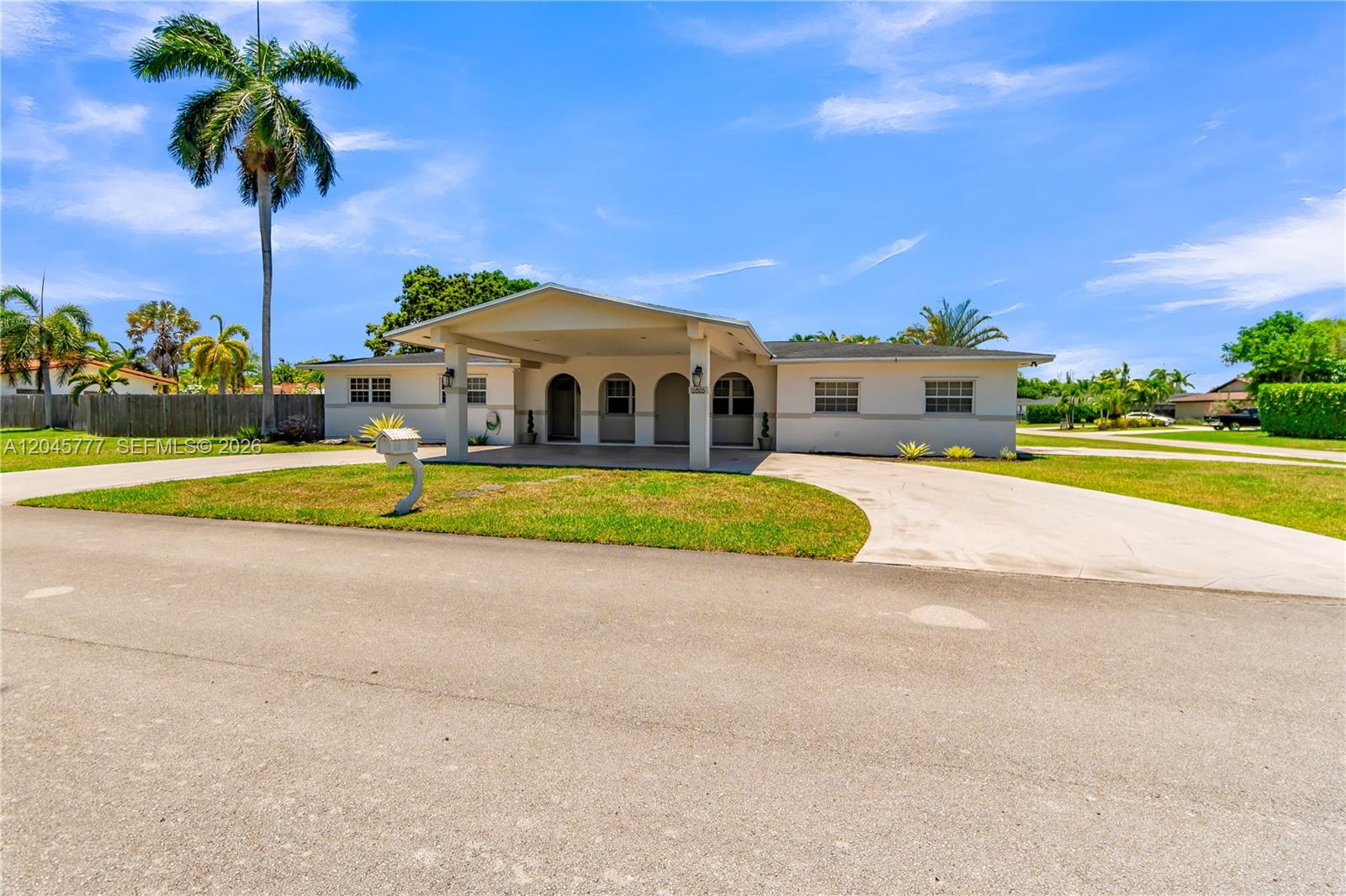 A single-story house with a covered entryway, arched doorways, and a concrete driveway — 12805 SW 193rd Ter, Miami FL 33177, MIAMI, FL