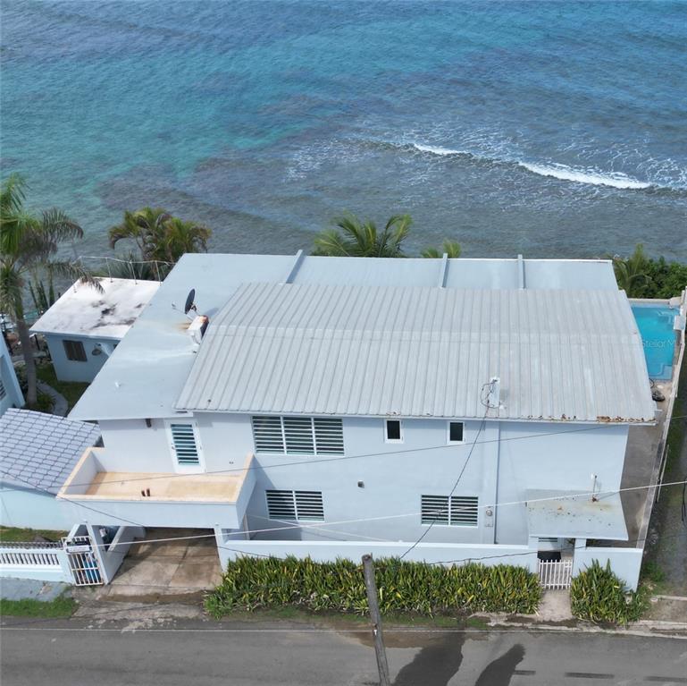 An aerial view of a light blue house with a metal roof near the ocean — 365 NORTH SHORE POINTE, VIEQUES, PR