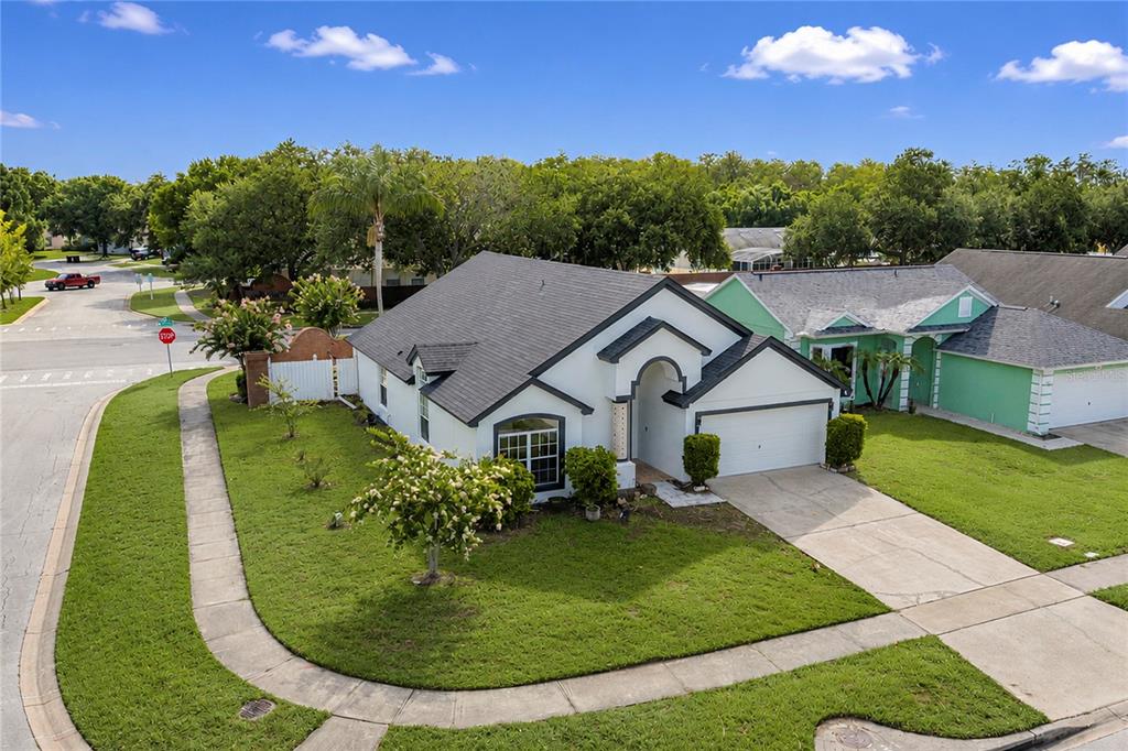 An aerial view of a white single-story house with a dark roof and corner lot — 2039 SHANNON LAKES BOULEVARD, KISSIMMEE, FL