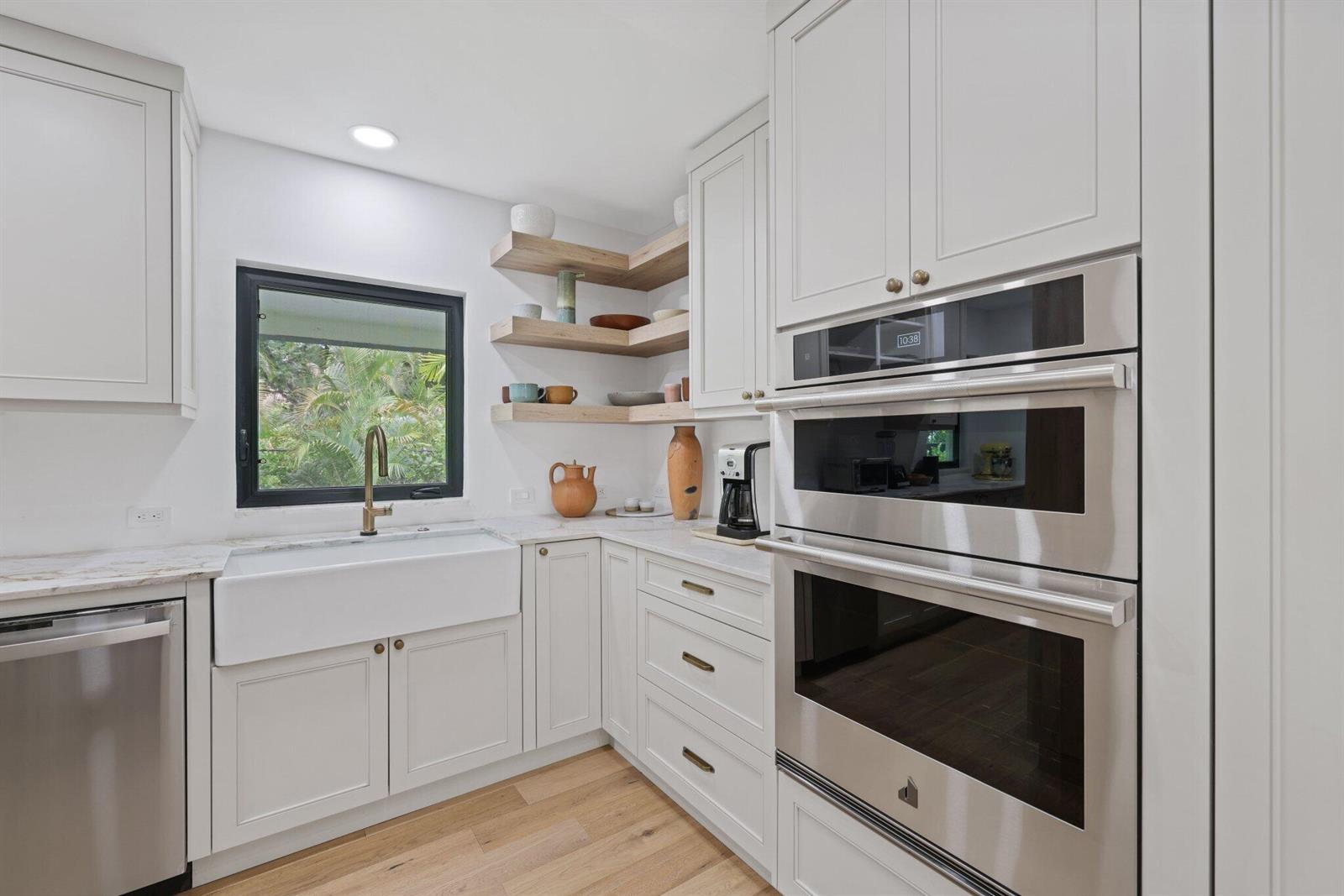 A bright entryway features light wood floors, a black double door, and a glass-enclosed sitting area — 3235 Hyde Circle, Boca Raton FL 33434, BOCA RATON, FL