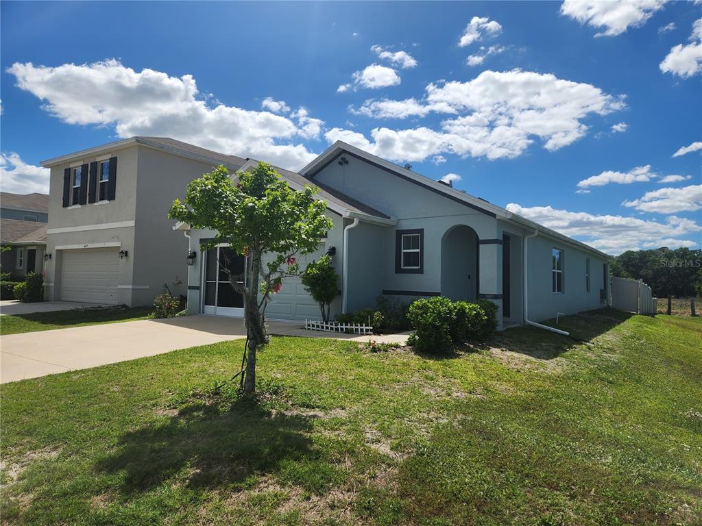 A light blue single-story house with a garage and a small front yard — 6643 LONGBOAT DRIVE, BROOKSVILLE, FL