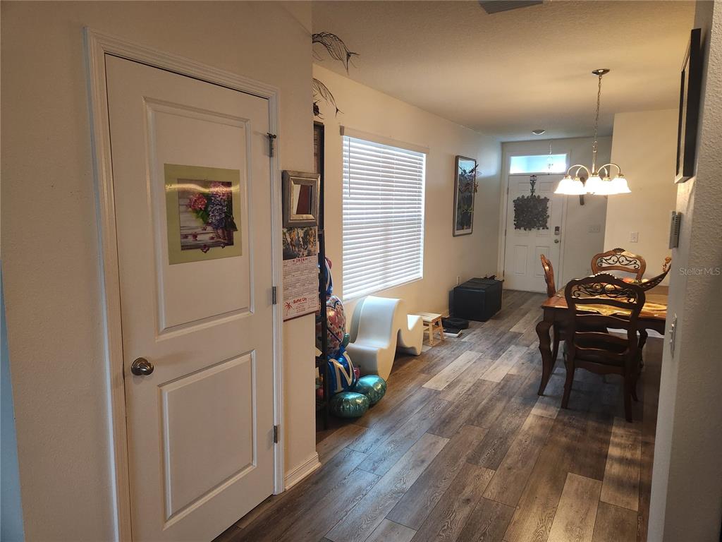 A view of a home interior featuring a white door, dining area, and wood-look flooring — 6643 LONGBOAT DRIVE, BROOKSVILLE, FL