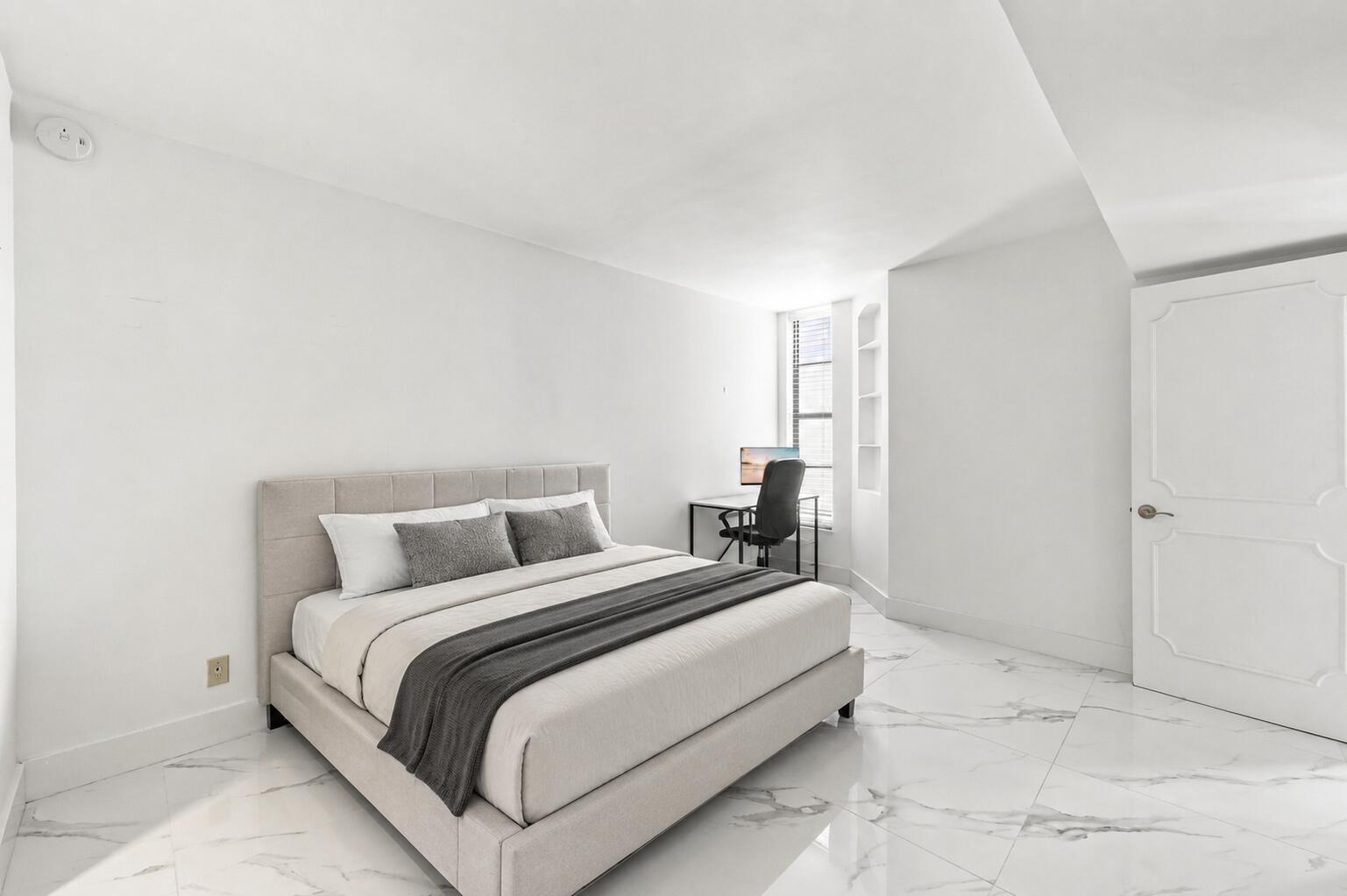 A bedroom with white walls, marble-patterned tile floors, a beige bed, and a corner desk — 1000 S Ocean Boulevard # 14o, Pompano Beach FL 33062, POMPANO BEACH, FL
