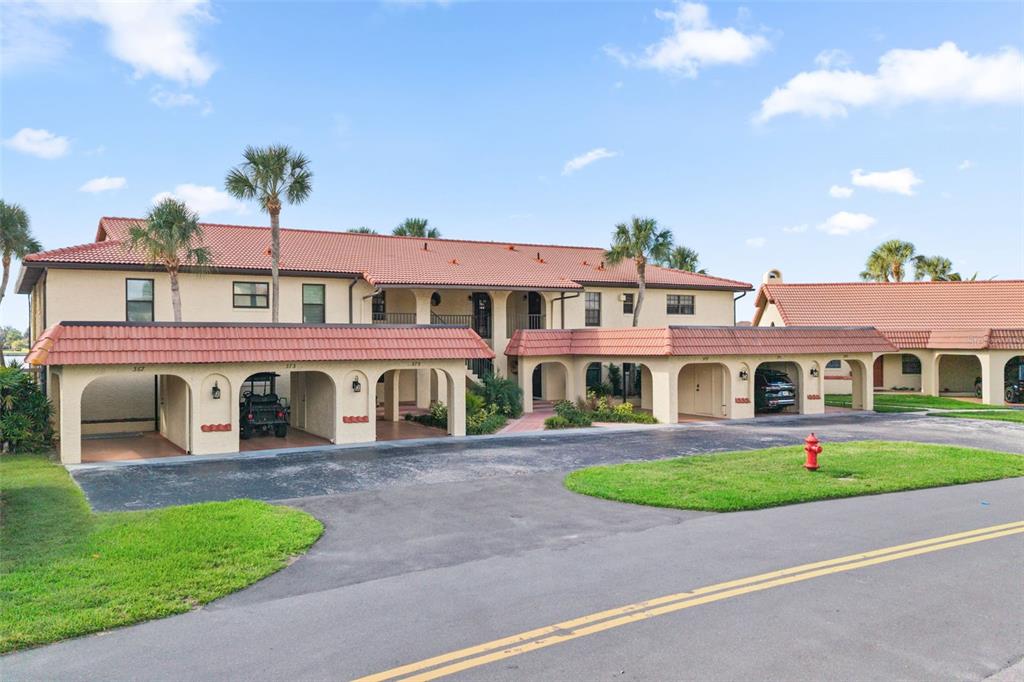 A two-story apartment building with a red tile roof and covered parking bays — 371 NW 14TH PLACE, CRYSTAL RIVER, FL